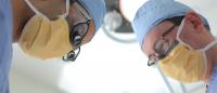 Two urology surgeons working side by side in the operating room